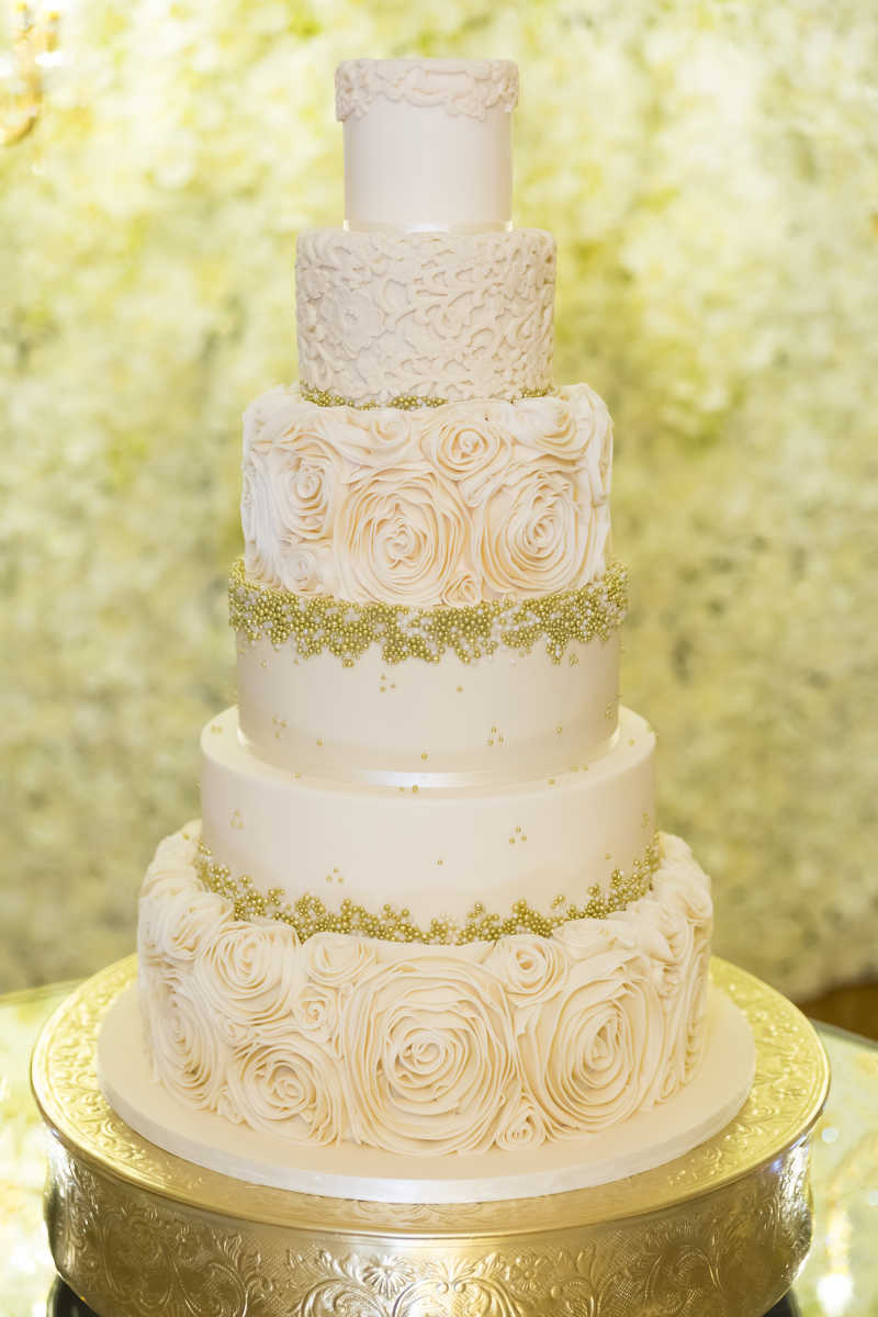 Classic elegant wedding cake with roses and gold accents